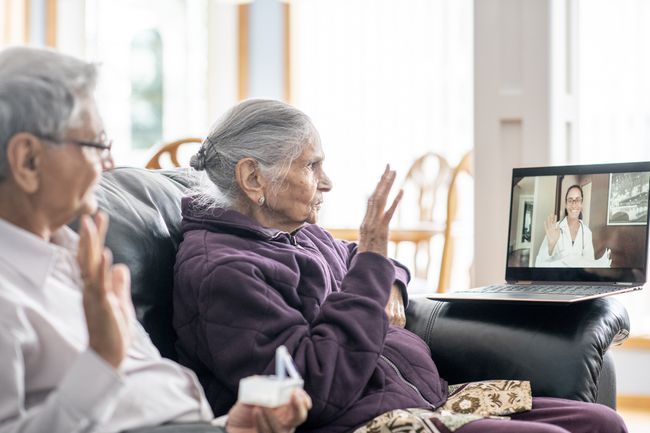 Una coppia di anziani che ha un consulto con un operatore sanitario in realtà virtuale. 