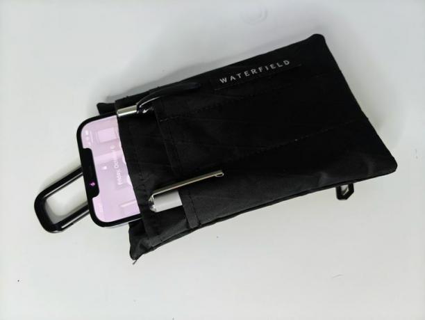 กระเป๋า Waterfield iPhone 15 EDC บนโต๊ะที่มี iPhone และปากกาอยู่ในนั้น