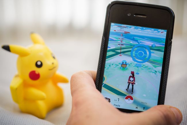 Pokemon Go på en smartphone med en Pikachu-leksak i bakgrunden