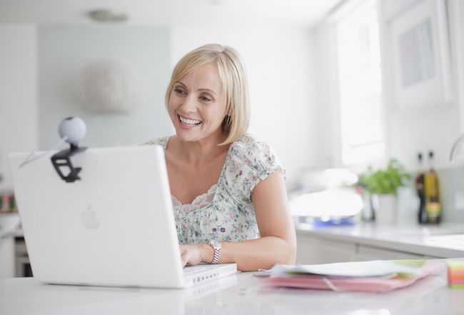 Seorang wanita menggunakan webcam di komputer laptop.