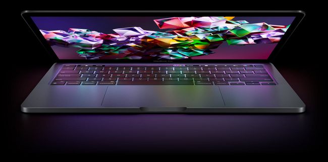 Apple M2 MacBook Pro、暗い背景に対して半分閉じています。