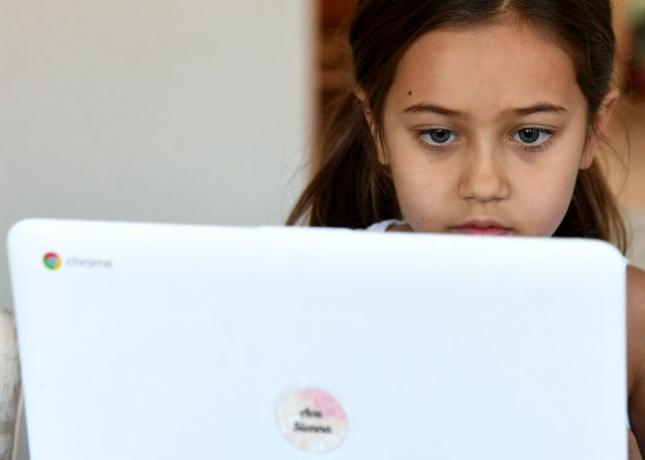 Goolsby Elementary School derdeklasser Ava Dweck volgt een online les bij een vriend thuis tijdens de eerste week van afstandsonderwijs