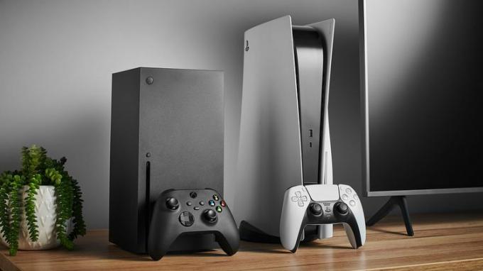 テレビのあるエンターテイメント センターに隣り合って設置された Xbox Series X と PS 5。