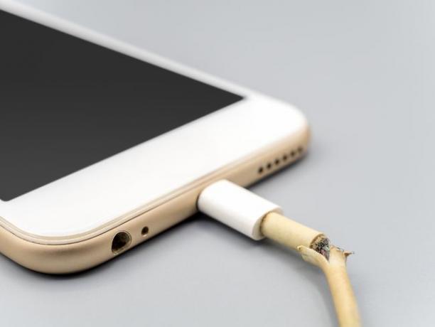 Kabel Lightning yang rusak dicolokkan ke iPhone.