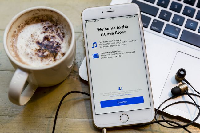 Ekran powitalny sklepu iTunes Store na iPhonie na klawiaturze z kubkiem gorącej czekolady