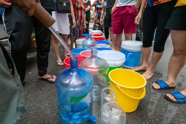 緊急移動式タンクローリーからの淡水を待っている空の水バケツ。