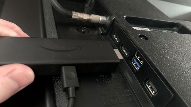 Un Amazon Fire TV Stick este conectat la portul HDMI al unui televizor inteligent.