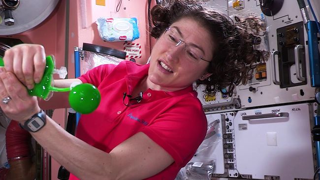Astronautti leikkii liman kanssa mikrogravitaatioympäristössä.
