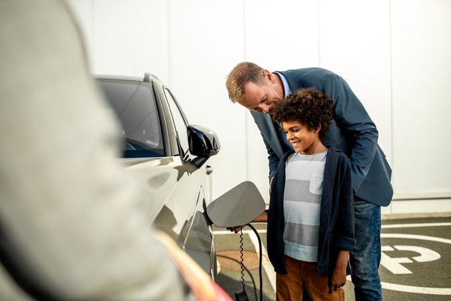 電気自動車について子供と話している自動車販売のスペシャリスト。