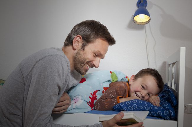 Padre leyendo un cuento a su hijo antes de acostarse.