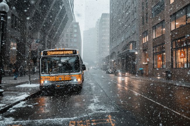 バスが乗って雪が降る街並み。 