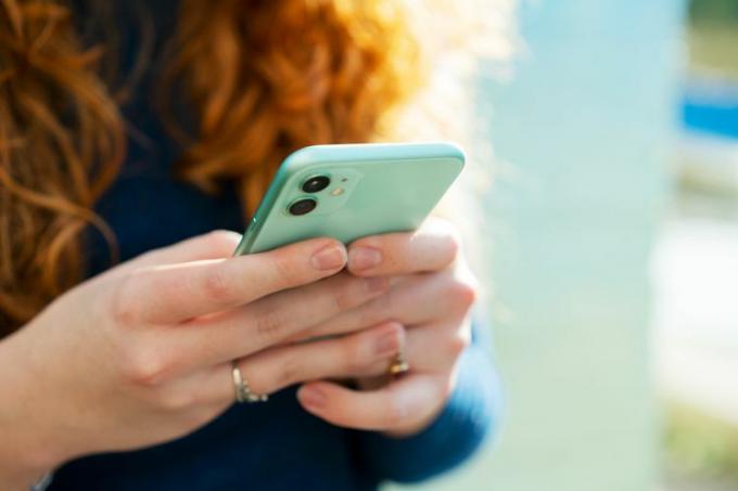 Rankos laikančios išmanųjį telefoną