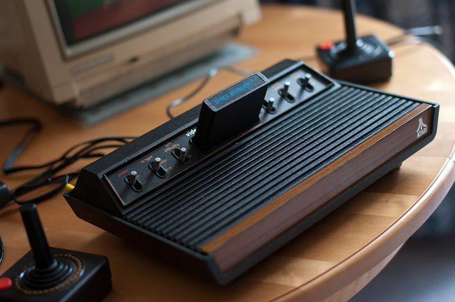 Atari 2600 VCSコンソール、フルビュー、ジョイスティックとCommodore1084Sモニターが部分的に表示されます。 1978年6スイッチモデル。 スペースインベーダーゲームが挿入されます。