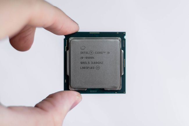 Крупним планом людини тримає процесор Intel Core i9 кінчиками пальців.