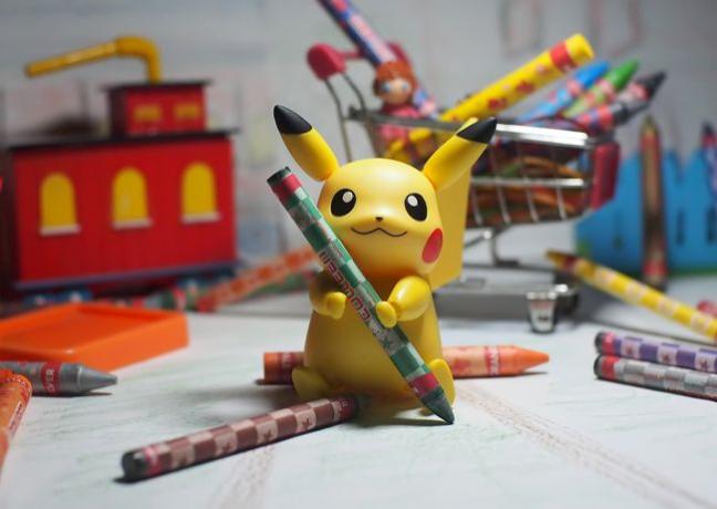 Personaje de Pikachu Pokemon sosteniendo crayones.