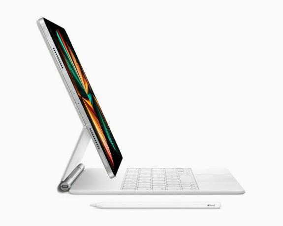 M1 チップを搭載した新しい iPad Pro の側面図。近くにある Apple pencil でマジック キーボードに接続します。