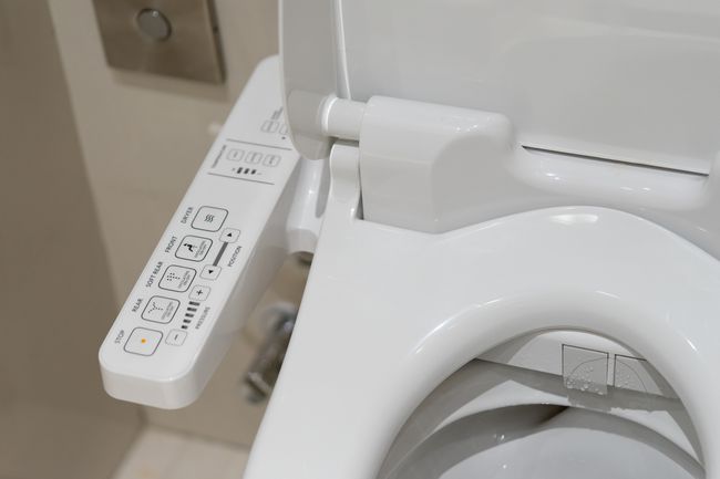 Fotografie ovládacích prvků na bílé chytré toaletě