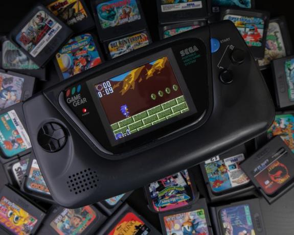 Портативний портативний пристрій Sega GameGear в оточенні ігрових картриджів.