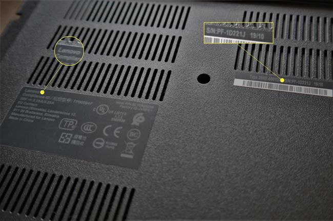 O fotografie cu partea de jos a unui laptop cu numărul de serie și numele producătorului evidențiate.