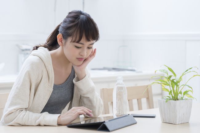 iPadでソフトウェアをダウンロードする女性