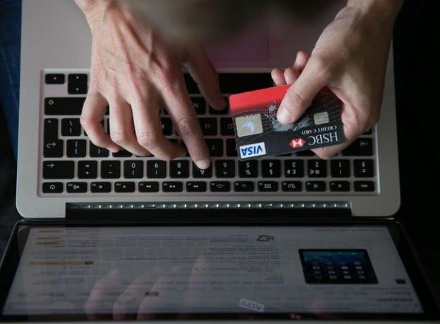 여자는 신용 카드를 사용하여 온라인에서 무언가를 구매합니다.