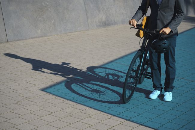 Κάποιος στέκεται με ένα ποδήλατο σε έναν δρόμο.