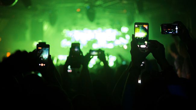Instagram용 부메랑을 만들기 위해 음악 콘서트에서 비디오를 찍는 사람들의 그룹