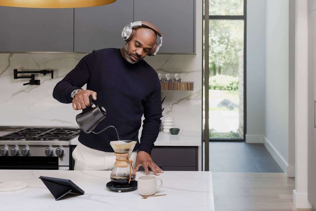 Nogen, der lytter til en lydbog på en Kobo Sage, mens han laver en kop kaffe i køkkenet.