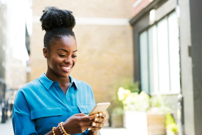 スマートフォンを使用して笑顔の女性