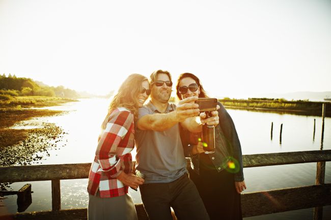 Drie vrienden die zelfportret maken met smartphone