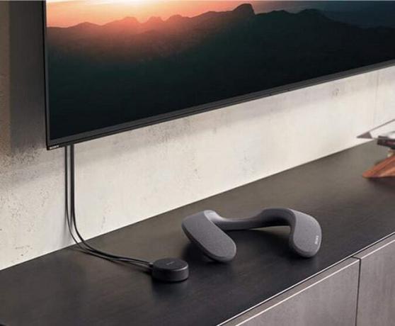 Głośnik Sony z pałąkiem na kark spoczywający w pobliżu telewizora