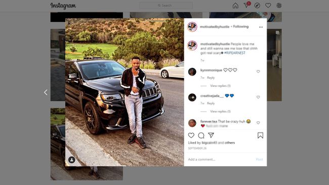 Un influencer Instagram stând în picioare în fața vehiculului