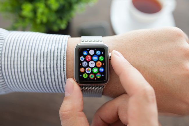 Mandshånd med Apple Watch og app-ikon på skærmen