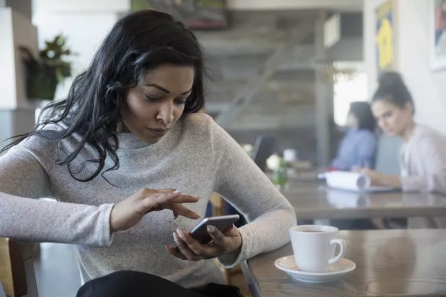 Mulher verificando seu e-mail em um iPhone