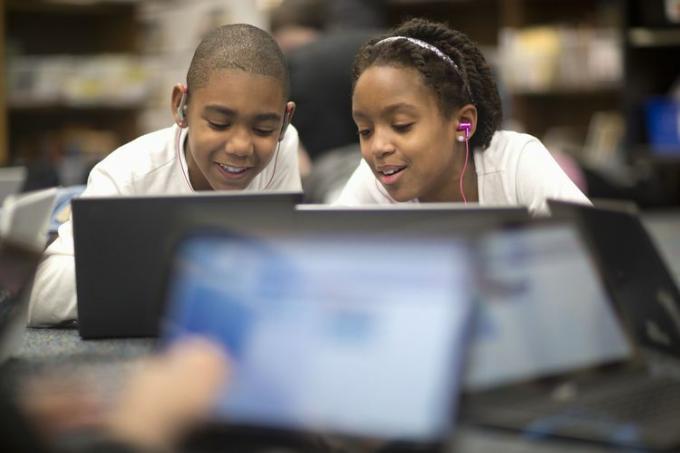 Dos niños haciendo los deberes en una laptop