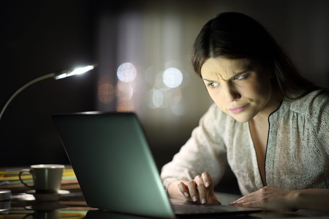 Verdächtige Frau, die nachts den Inhalt des Laptops überprüft