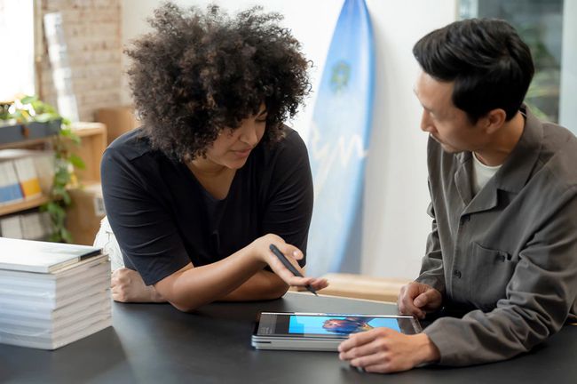 Deux personnes collaborant sur un ordinateur portable Surface Pro en mode tablette.