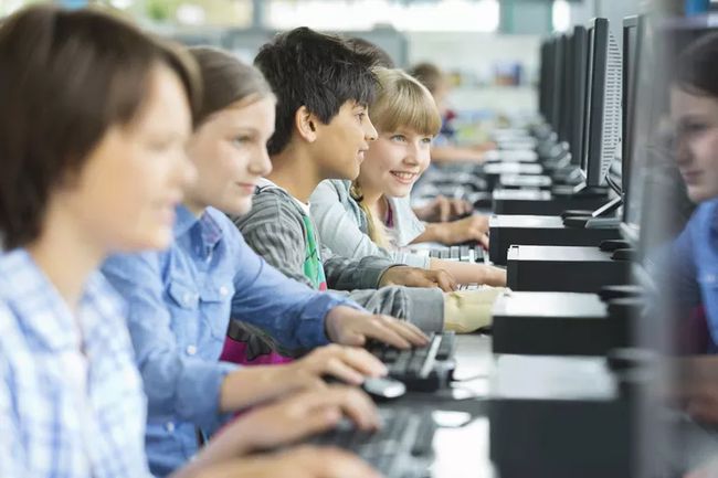 Estudiantes que usan computadoras en la escuela.