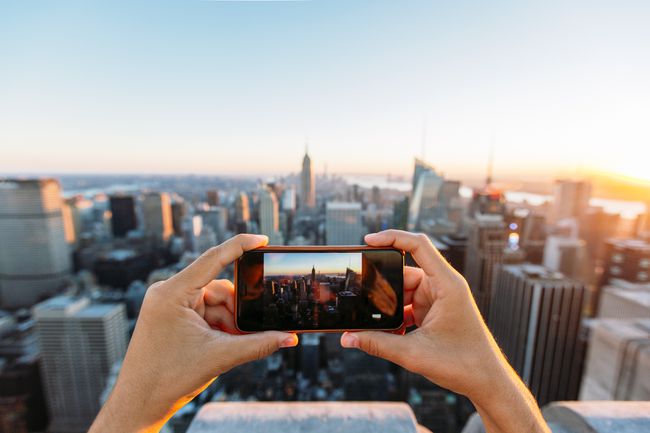 Vīrietis fotografē ar telefonu