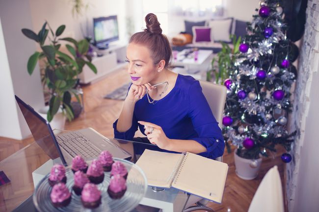 Lächelnde Frau mit Laptop-Computer zu Hause