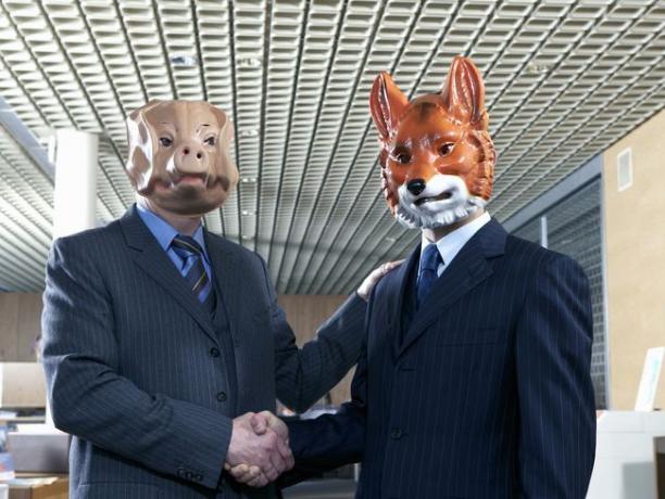 Hommes d'affaires se serrant la main avec des masques d'animaux