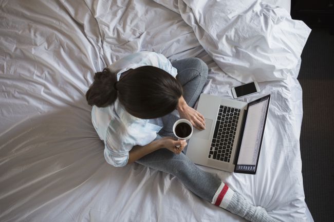 Vista aérea de la mujer con café en la computadora portátil