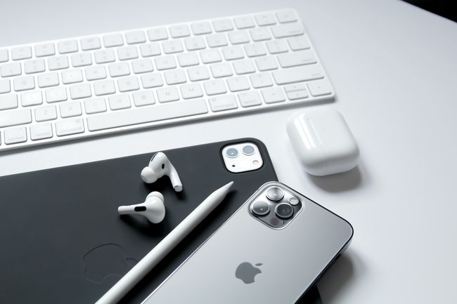 iPad, Apple AirPods Pro, iPhone, Apple Pencil и клавиатура на Apple, подредени на бюро (екосистемата на Apple).