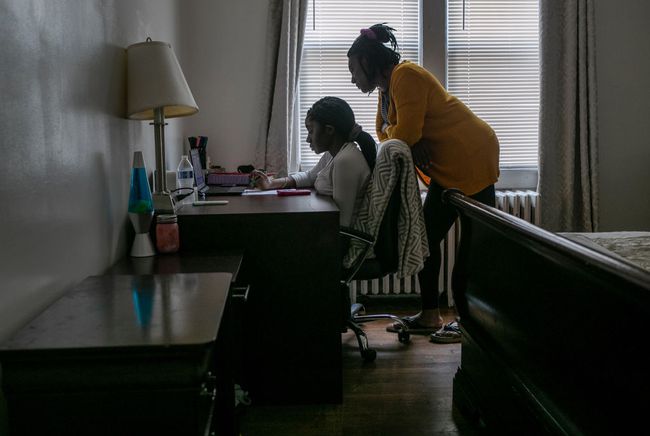 Abigail Previlon neemt deel aan afstandsonderwijs op een Chromebook met de hulp van haar moeder Carlene thuis in Stamford, Connecticut