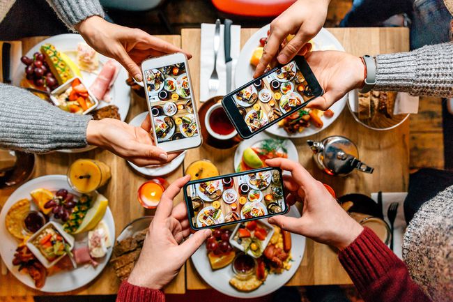 食べ物の写真を撮る3人のダイナー。