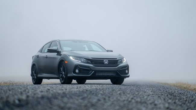 霧の道に駐車した灰色のホンダセダン