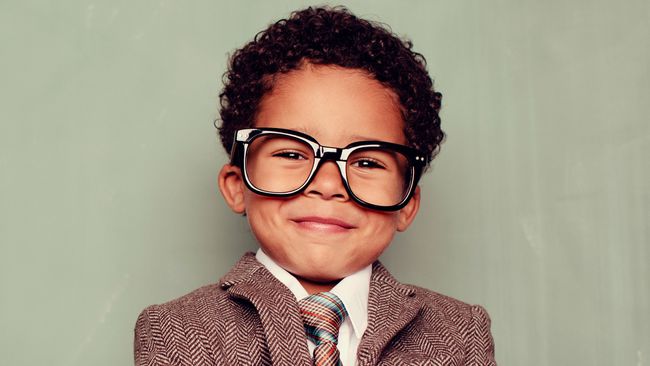 Un niño con gafas y traje.