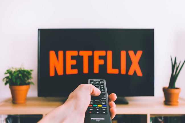 「Netflix」が表示されているテレビにパナソニックのリモコンを向けている人