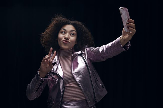 Žena, která dělá znamení míru při selfie.