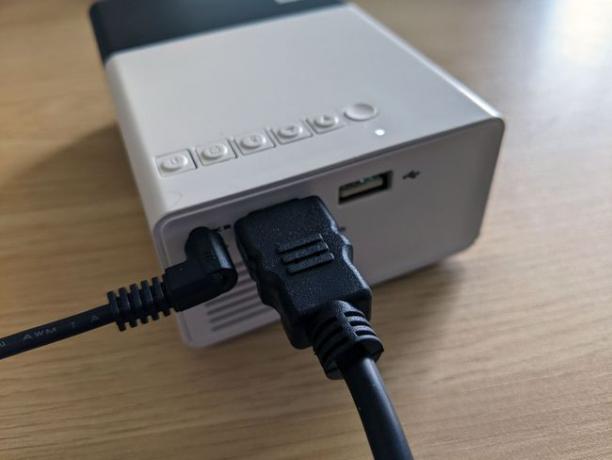 Mini projektöre takılı bir HDMI kablosu.